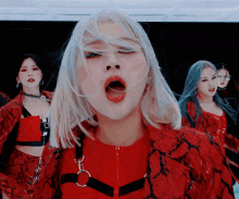 a woman with white hair is wearing a red jacket with a zipper