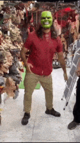 a man wearing a green mask is standing in front of a ladder in a store .