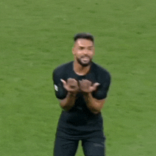 a man with a beard is standing on a soccer field .