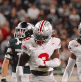 a football player wearing a number 2 jersey runs with the ball