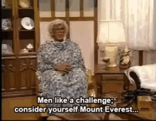 a woman is sitting in a chair talking about men like a challenge