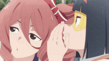 a woman whispering into another woman 's ear
