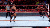 two men are wrestling in a wrestling ring with a referee .