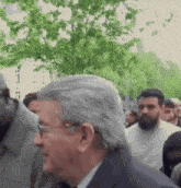a man in a suit and tie stands in a crowd
