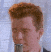 a close up of a man singing into a microphone