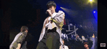 a man singing into a microphone on a stage