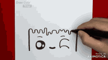 a person is drawing a face with a marker on a piece of paper