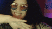 a woman wearing sunglasses is smiling in front of a wall that says gang 16/30