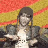 a man wearing a beanie and a jacket is holding a microphone on a stage .
