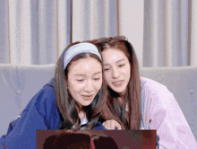 two women are looking at a computer screen together