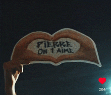 a person holding a sign that says pierre on t aime