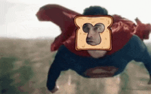 a man in a superman costume is flying through the air with a slice of bread on his face .