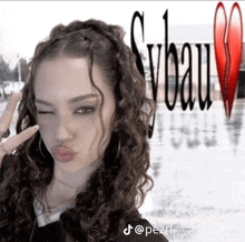 a girl with curly hair is making a peace sign in front of a broken heart and the word vbeau