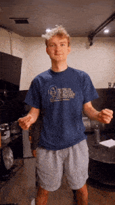 a young man wearing a blue t-shirt that says work in progress institute