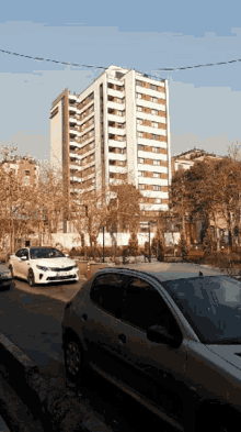 a white car with a license plate that says ' a ' is parked in front of a tall building