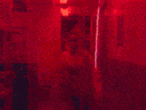 a woman wearing headphones and a pink jacket stands in front of a red curtain
