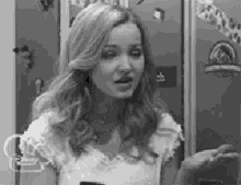 a black and white photo of a woman talking to someone .