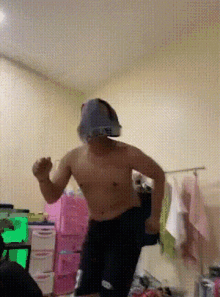 a man without a shirt is dancing in a room with a bunch of pink boxes