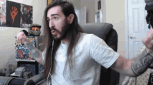 a man with long hair and a beard is wearing a white shirt with the word gfu on it