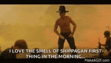 a man in a cowboy hat is dancing in front of a group of soldiers in the desert .