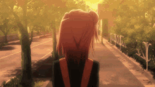 a girl with red hair is walking down a street with trees