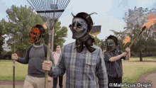 a group of people walking in a park with maleficus origin written on the bottom right