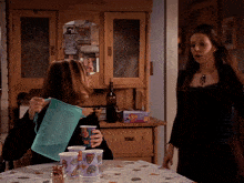 a woman pouring a pitcher of water into a cup with a butterfly design