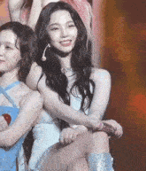 a woman in a white dress sits next to another woman