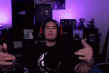 a man wearing headphones is sitting in front of a microphone and making a funny face .