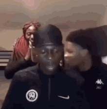 a group of people are standing next to each other in a room . one of the men is wearing a nike shirt .