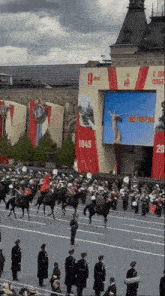 a military parade with a large screen that says 1945
