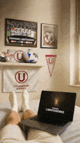 a person laying on a bed with a laptop that says libertadores