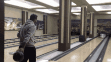a man throws a bowling ball on a bowling alley