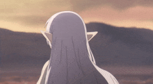 a woman with long white hair and elf ears is standing in front of mountains
