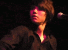 a woman singing into a microphone with a blurred background