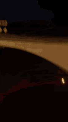a red car is driving down a road with smoke coming out of the hood