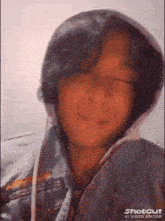 a close up of a person wearing a hoodie with their eyes closed