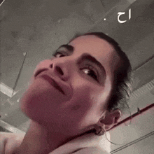 a close up of a woman 's face making a funny face in a parking garage .