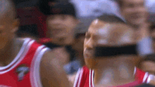 a basketball player is taking a picture of another player during a game .