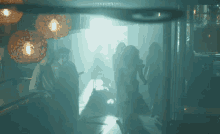 a group of people standing in a dark room with a light shining on them