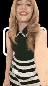 a woman wearing a black and white striped dress smiles