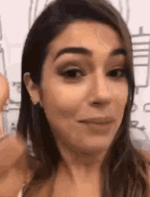 a close up of a woman 's face making a funny face while looking at the camera .