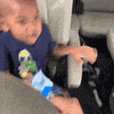 a young boy in a blue shirt is sitting in a plane seat