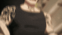 a blurry image of a person with tattoos on their arms .