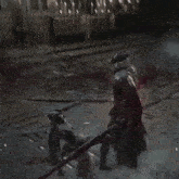 a man in a black cape is holding another man 's arm in a dark room
