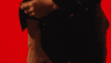 a man without a shirt is standing in front of a red light