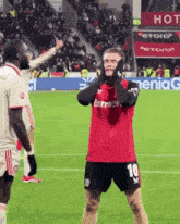 a soccer player with the number 10 on his shorts is covering his ears