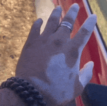 a close up of a person 's hand with a silver ring on it