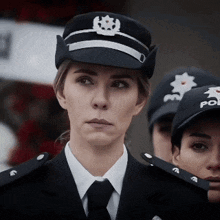 a woman in a police uniform stands in a line with other officers