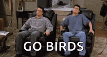two men are sitting in chairs with the words go birds on the bottom